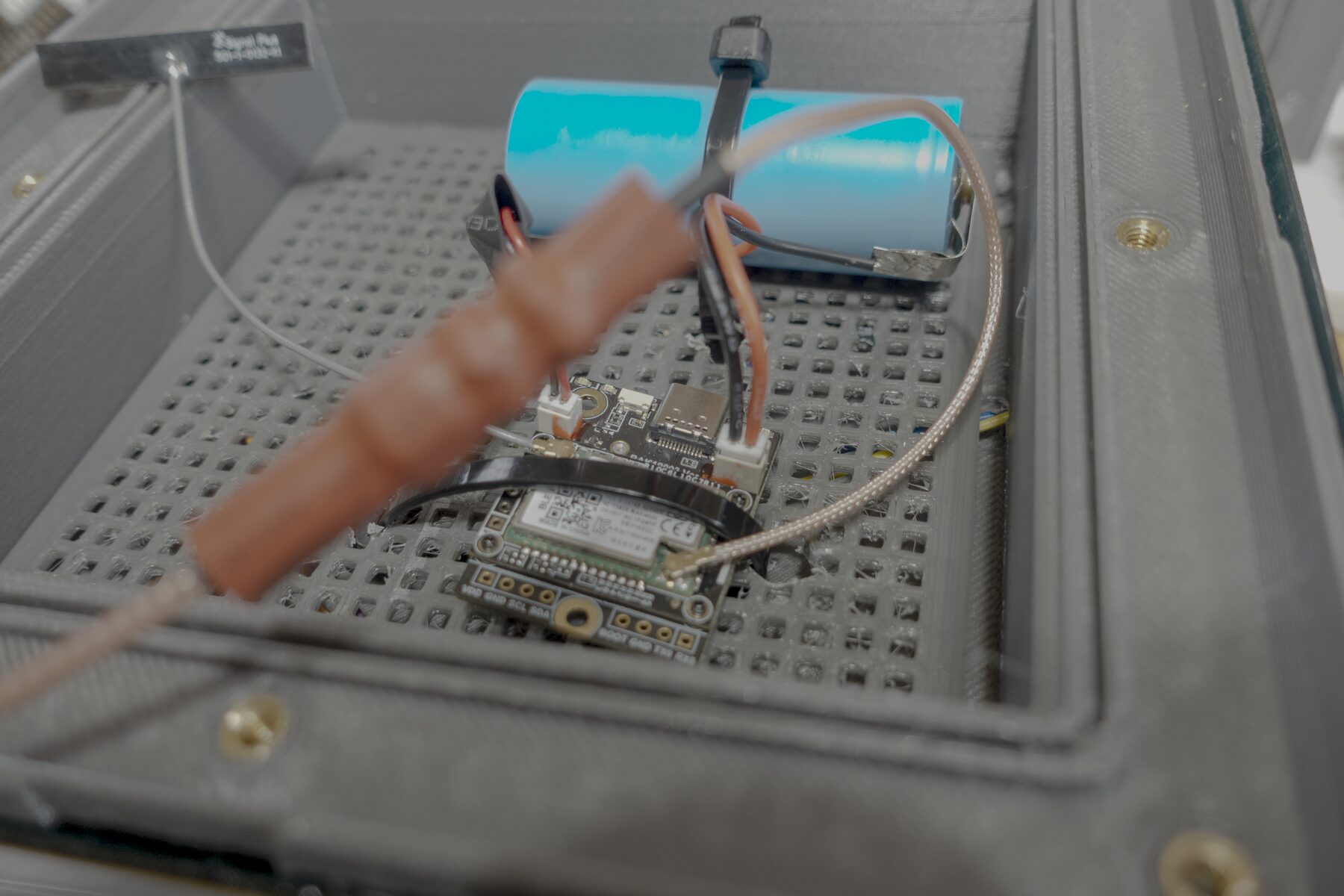 Internal control board, antenna lead, wiring, and battery inside the lantern node enclosure.