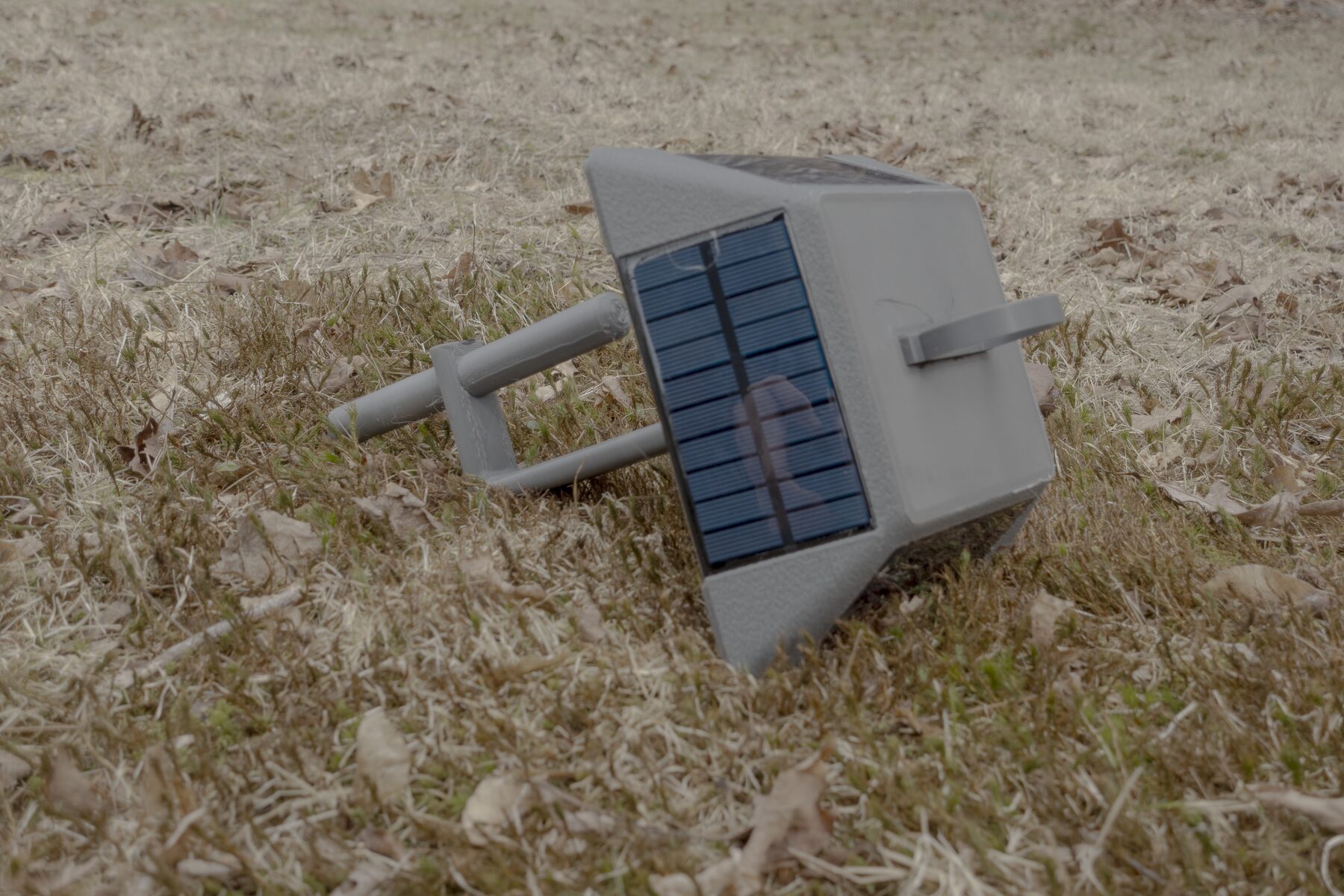 Lantern node on grass showing the solar panel side and side access door.